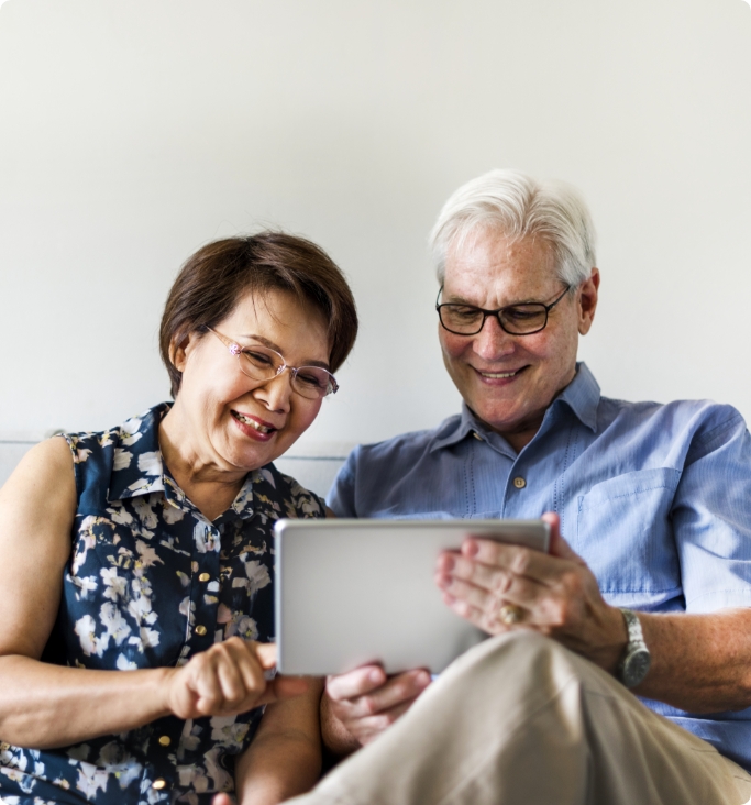 senior-couple-using-digital-device-living-room